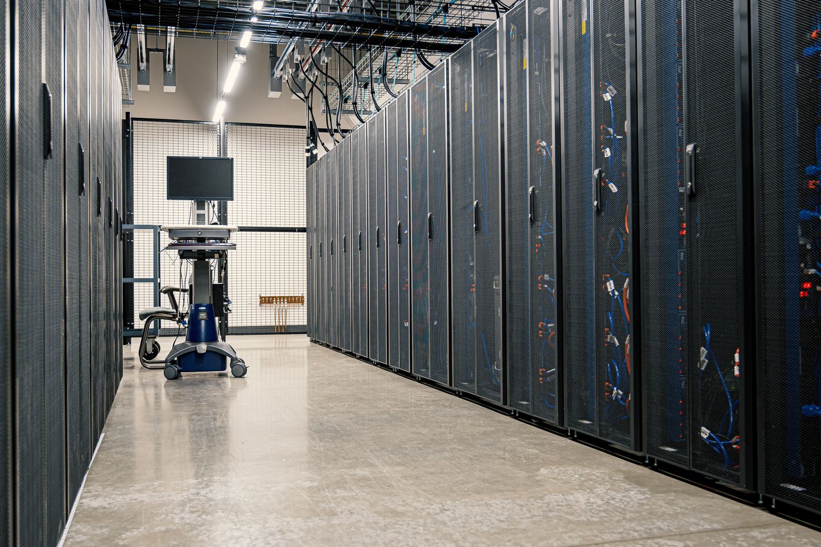 Aisle between dark server cabinets in a modern data center